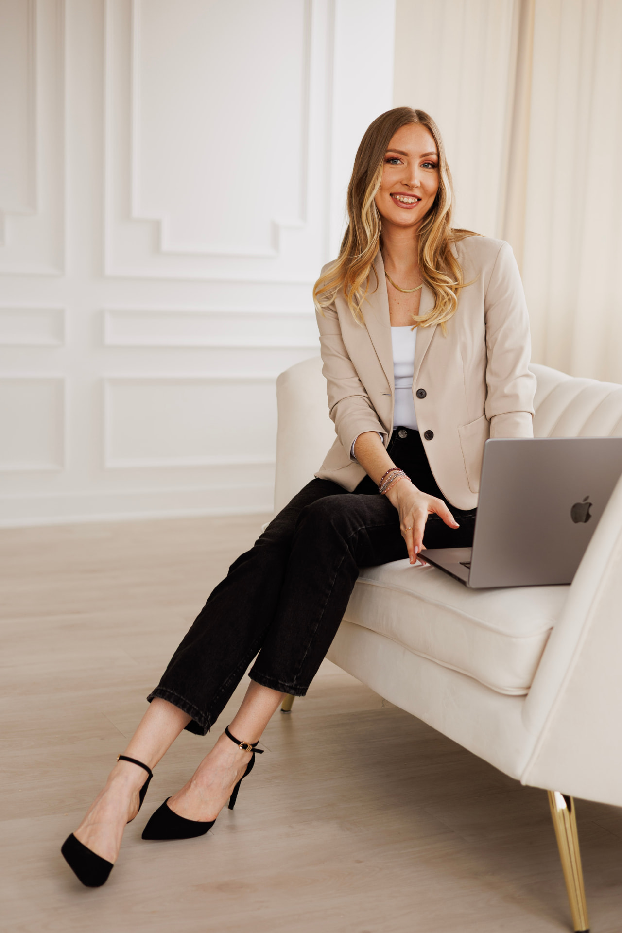 Kateryna Moskaliuk seated with a laptop in a bright studio
